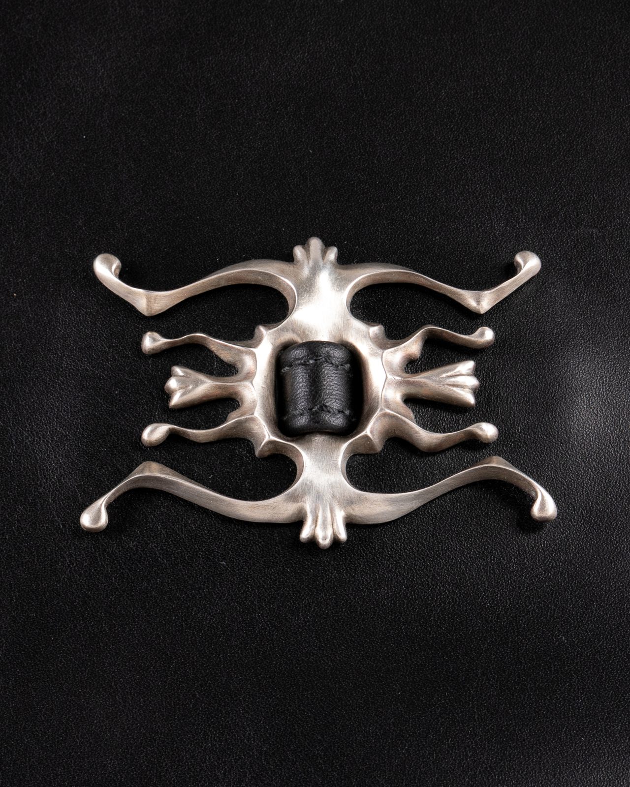 Silberornament auf schwarzem Leder